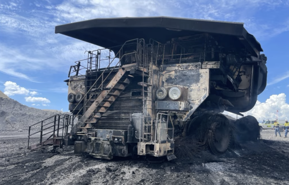 Burned-out EH5000 haul truck at Whitehaven’s Maules Creek mine after a tyre fire caused by park brake piston seal failure, illustrating catastrophic mining equipment loss.